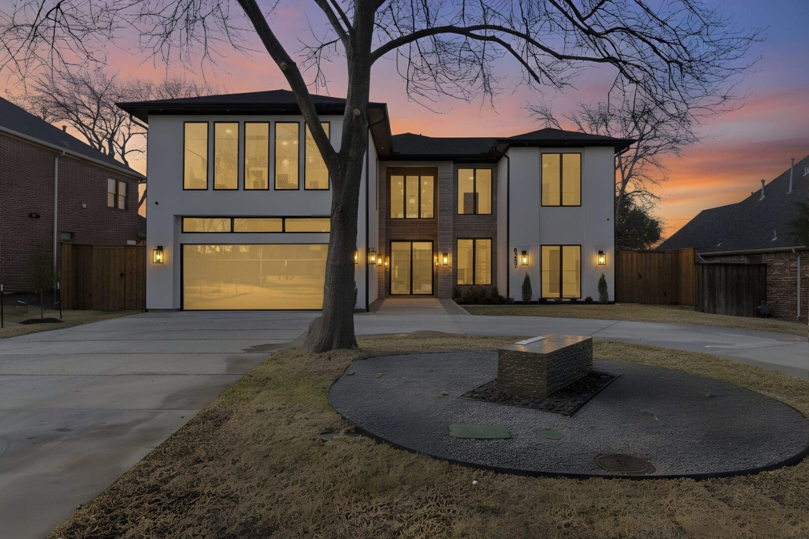 Modern two-story house with large windows at dusk.